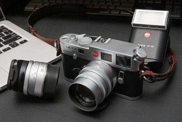 Leica M6 Analog Camera next to a flash and laptop